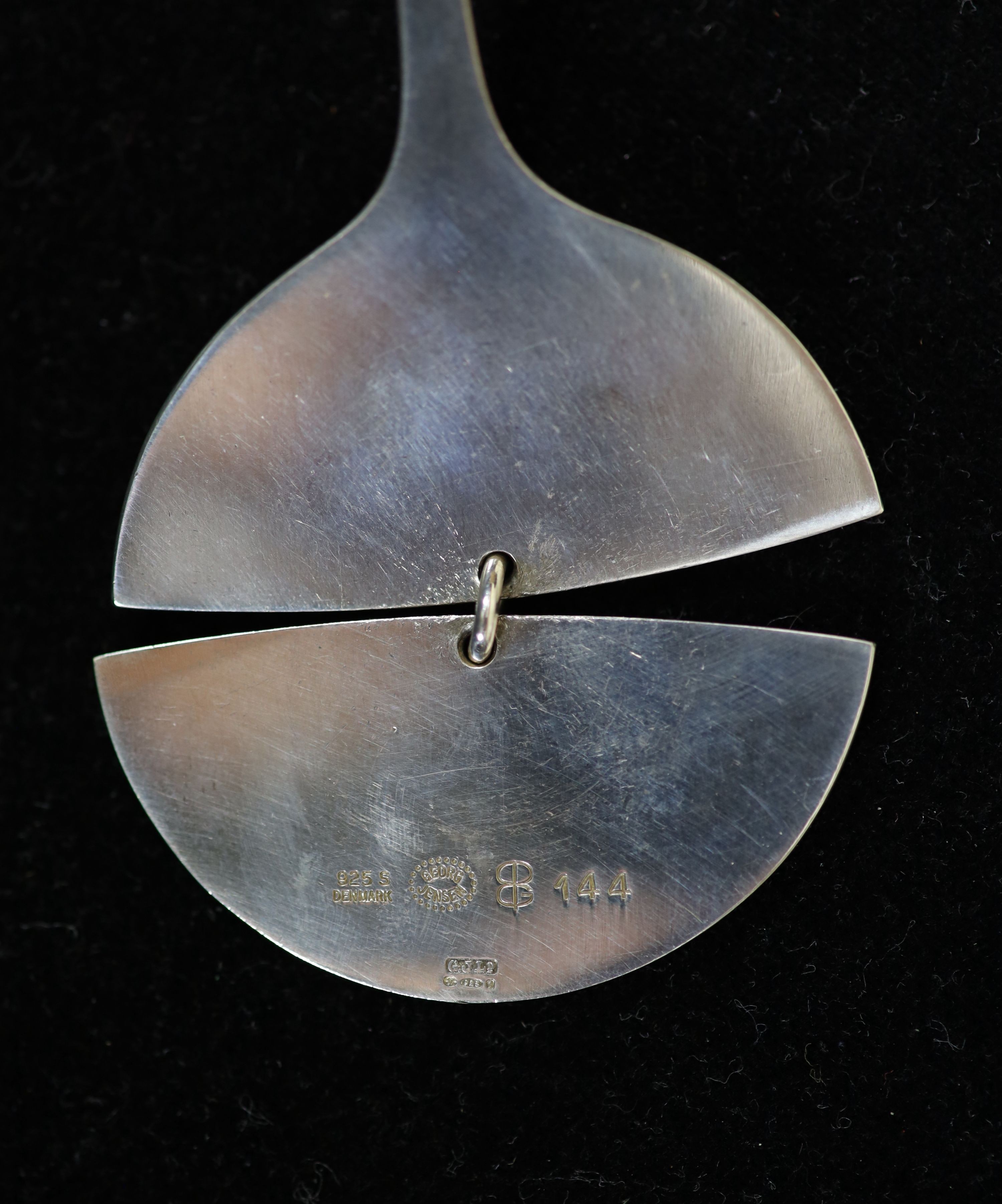 A Georg Jensen sterling silver drop pendant, no. 144, together with a Georg Jensen Torun sterling silver torque necklace, no. 169